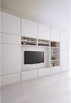 an entertainment center with white cabinets and a flat screen tv mounted on the wall in front of it