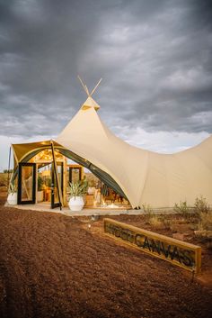 a large white tent sitting on top of a dirt field