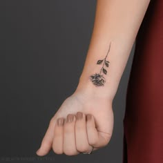 a woman's hand with a rose tattoo on it