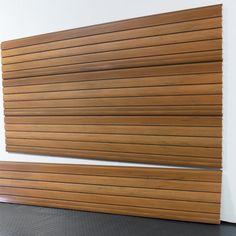 a wooden slatted wall next to a white wall