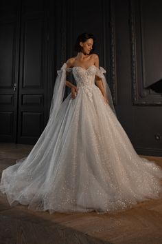 a woman in a wedding dress standing on the floor