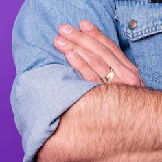 a close up of a person wearing a ring on their left hand and his right arm wrapped around him