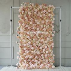 an arrangement of pink and white flowers on a wall