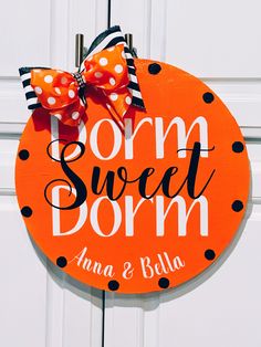 an orange sign with polka dots and a bow on it that says tom sweet dorm