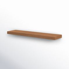 an empty wooden shelf against a white wall