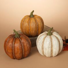 three decorative pumpkins sitting on top of a table