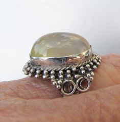 "This is a large vintage 1980s sterling silver ring with an oval pale orange/gray Mango Chalcedony cabochon stone.  This stone is an unusual color that appears more orange in indoor lighting, but is a very pale translucent color.  The face of the ring measures almost 1\" long and is over 1/2\" deep.  The band is size 7 1/2 and is not marked, but was acid-tested as 925 sterling silver.  The ring is in excellent condition with no sign of any wear and no damage.    FREE SHIPPING within the USA and Vintage Round Cabochon Moonstone Ring, Vintage Moonstone Oval Cabochon Ring, Collectible Oval Cabochon Moonstone Ring, Vintage Cabochon Moonstone Ring, Vintage Adjustable Oval Moonstone Ring, Bali Style, Chalcedony Ring, Pale Orange, Bali Fashion