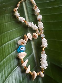 One of a kind! Made with love, care, and only positive intention. This beach inspired necklace is blend of shell chips and nuggets,  with different size genuine freshwater pearls and highlighting a large sky blue-glass evil eye. Length 15.75'' Gold plated brass spring ring clasp round ring Lead, cadmium and nickel free Spiritual Jewelry With Natural Stones For Vacation, Spiritual Natural Stone Jewelry For Vacation, Heishi Beads Strand Necklaces As Gift, Spiritual Beach Necklace With Colorful Beads, White Adjustable Shell Necklace Spiritual Style, White Adjustable Spiritual Shell Necklace, Handmade Spiritual Necklaces For Vacation, White Adjustable Shell Necklace For Spiritual Wear, White Bohemian Necklace With Evil Eye