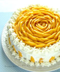 the cake is decorated with white icing and orange swirls on it's edges