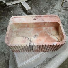 a pink sink sitting on top of a table