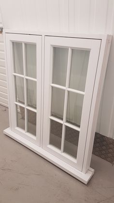 a white window sitting on top of a cement floor