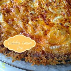 a casserole dish with cheese and onions in it on a glass platter