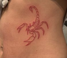 a scorpion tattoo on the side of a woman's stomach is shown in red ink