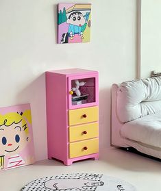 a pink dresser next to a white couch