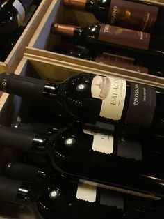 several bottles of wine are lined up in a wooden box on top of each other