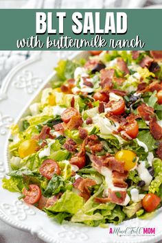 a salad with bacon, lettuce and tomatoes in it on a white plate