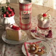 strawberry shortcakes are on plates next to a can of cookies