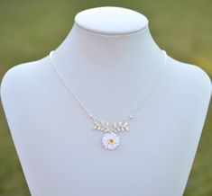 "2018 COLLECTION, ATHENA. A nature inspired necklace featuring white Gerbera with Yellow Center dangled on metal branch. Perfect for bridesmaid gift or flower girl jewelry. Detail : - Hand sculpted flower made of Polymer Clay . Size approx: 17mm. - Silver plated over brass branch as pictured. - Cream Swarovski Pearls - Silver Plated over brass chain as pictured, gold plated, rose gold available. - Entire length 16\" + 2 extenders. - Made to order in 3-4 business days. If you need earlier shippin White Sterling Silver Charm Necklace With Flower, White Sterling Silver Charm Necklaces With Flower Charm, Delicate White Flower Charm Necklaces, Delicate White Flower Charm Necklace, White Flower Necklace With Nature-inspired Style, White Flower Pendant Jewelry With Adjustable Chain, White Flower-shaped Nature-inspired Necklace, Adjustable White Nature-inspired Necklace, White Adjustable Nature-inspired Necklace