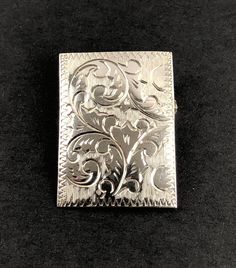 This is a lovely estate sterling silver rectangular domed pin brooch featuring an engraved floral, botanical, Art Nouveau design. It has a functional roll over catch. The pin is hallmarked STERLING and tests positive for sterling silver with the 18K acid solution (video of testing is available upon request, prior to purchase). A partial maker's mark is also visible.  Weight: 4.27 G Length: 1.23" (3.1 cm) Width: 0.89" (2.26 cm) Very good estate preowned condition (see photos, video). A tarnish-re Silver Engraved Heirloom Brooches, Silver Heirloom Engraved Brooches, Classic Engraved Brooches For Formal Occasions, Collectible Engraved Silver Brooch, Silver Engraved Brooches For Formal Occasions, Classic Silver Engraved Brooches, Classic Engraved Silver Brooches, Black Patch, Art Nouveau Design