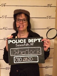 a woman holding up a sign that reads police dept, spencer falls, n y