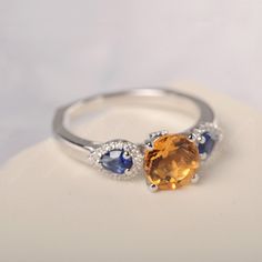 All HANDMADE ITEMS SHIP IN APPROX 8 DAYS Main Stone: Genuine natural citrine Main Stone Size: Round cut 7 mm x 7 mm Main Stone Weight: 1.30 carat Side Stone: Lab created blue sapphire,CZ Height From The Ring Setting Bottom(to gemstone top): about 6.83 mm Width of Ring band Measure: gradually varied,about 2.05 to 2.50 mm Material: 925 Sterling Silver/14K White Gold/14K Yellow Gold/14k Rose Gold Engraved: Available For FreeNo more than 13 letters) Customized:Of course! Tell me what you want Includ Blue Topaz Ring Silver, Three Stone Engagement Ring, Wedding Rings Solitaire, London Blue Topaz Ring, Gold Engraving, Stone Engagement Ring, Three Stone Engagement, Three Stone Engagement Rings, November Birthstone