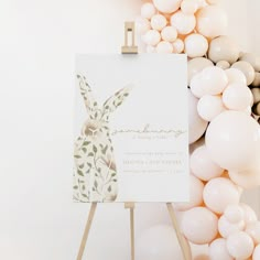 an easel with balloons and a card on it