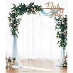 a wedding arch decorated with flowers and greenery