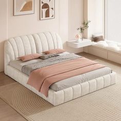 a white bed sitting in a bedroom on top of a hard wood floor next to a window