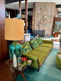 a living room filled with furniture and a large stone wall behind the couch is a fireplace