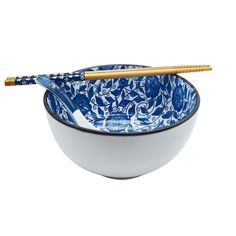 a blue and white bowl with chopsticks in the middle on a white background