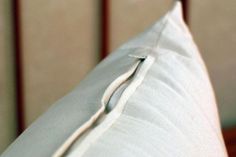 a close up view of a white pillow on a bed