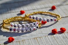 These little bracelets are dainty and a perfect little addition to any bracelet collection.  Each is composed of pretty galvanized gold seed beads and pretty, acrylic letter and heart beads that say LOVE.  Be Mine in separate listing: https://www.etsy.com/listing/1164681817/dainty-gold-seed-beaded-bracelet-with-be?click_key=1d1951875da351756aefaf5a9bc62d10ba533108%3A1164681817&click_sum=e78f509b&ref=shop_home_active_2&sts=1 Very fun on their own and to stack with other pieces and perfect for Val Valentine's Day Heart Bracelet With Letter Beads For Friendship, Heart Shaped Beaded Bracelet With Letter Beads As Gift, Valentine's Day Heart Bracelet With Letter Beads, Heart-shaped Letter Beaded Bracelets For Mother's Day, Cute Gold Beaded Bracelets For Mother's Day, Gold Name Bracelet With Round Beads For Valentine's Day, Valentine's Day Heart Charm Bracelet With Letter Beads, Valentine's Day Heart-shaped Charm Bracelet With Letter Beads, Friendship Letter Bead Charm Bracelet For Valentine's Day