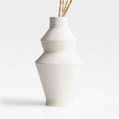 a white vase with three sticks sticking out of it