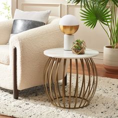 a living room with a chair, table and potted plant on the floor next to it