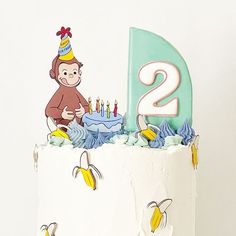 a birthday cake with a monkey on top and two candles in the shape of numbers