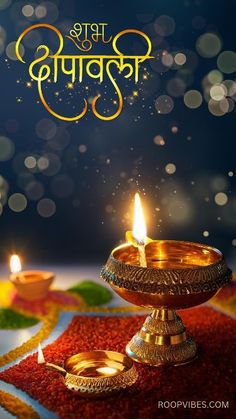 two candles on a colorful cloth with the words happy diwal