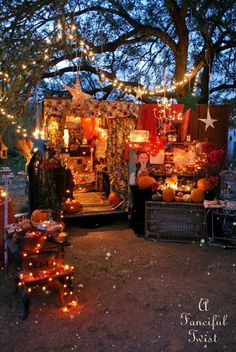 an outdoor market with pumpkins, candles and lights