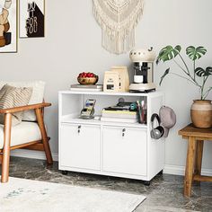 a living room area with white furniture and art on the wall, including a coffee table