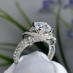 a close up of a diamond ring on a flower