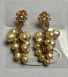 Beautiful vintage Miriam Haskell Baroque Pearl Cluster drop Earrings. Clip on/screw back, measures 2 inches long. Flower at the top with seed pearls sits on the earlobe. Both earrings are signed at the back, in perfect vintage condition with no wear to the pearls. The earrings come on the Miriam Haskell display card. A rare and beautiful find! Vintage Gold Earrings With Pearl Charm, Antique Clip-on Pearl Earrings For Wedding, Vintage Wedding Jewelry With Dangling Beads, Vintage Pearl Charm Drop Earrings, Vintage Drop Earrings With Pearl Charm, Vintage Pearl Clip-on Earrings For Formal Occasions, Vintage Pearl Drop Clip-on Earrings, Vintage Baroque Earrings, Victorian Pearl Drop Jewelry For Evening