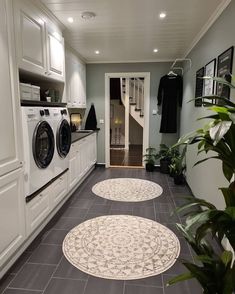 two circular rugs on the floor in a laundry room with washer and dryer