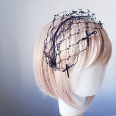 a mannequin head with a veil on top of it's headpiece