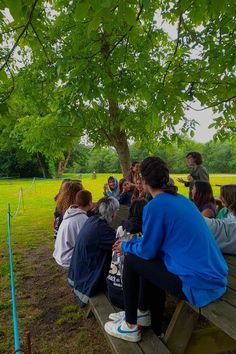 a group of people sitting on top of a wooden bench