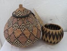 a basket and bowl sitting next to each other on a white tablecloth covered surface