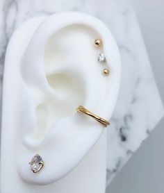 a pair of ear piercings sitting on top of a white marble surface