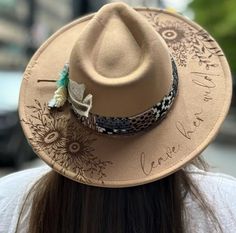 Leave Her Wild Floral Burned Hat, Floral Engraved Cowboy Hat, Sunflower Hat, Sunflower Burned Fedora, Engraved Fedora, Engraved Felt Hat, Boho Hat Elevate your style with our beautifully engraved floral hats! If you want certain colors for the feather/flower detail, please leave a note at checkout. Bands and florals/feathers may shift or fall off during shipping. The hat has an elastic band on the inside to fit many sizes. One size fits most adult heads. Bride Cowgirl Hat With Aunflowers, Burned Fedora Hat, Hat Bands Diy Ideas, Burning Hats, Cowboy Hats For Women, Burned Hats, Leave Her Wild, Hat Burning, Bohemian Hats