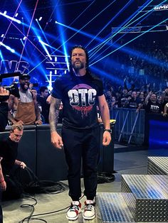 a man standing on top of a stage in front of a crowd