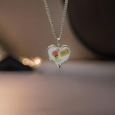 ✨ *Are you ready to explore the world, or perhaps, gift someone special the reminder to chase their dreams? This beautiful heart-shaped pendant necklace is a gentle nod to adventure, adorned with a delicate floral illustration and a whimsical 'Ticket to Anywhere' tag.* ✨ **Product Features - **Design A silver-tone heart pendant with a stunning floral decal, featuring a soft pink flower in a vase and a'Ticket to Anywhere' decal - **Material High-quality silver alloy, durable and lightweight, perf Valentine's Day Gift Charm Necklaces, Valentine's Day Keepsake Necklaces With Charms, Spiritual Charm Necklace For Valentine's Day Gift, Heart-shaped Birth Flower Necklace For Keepsake, Keepsake Birth Flower Heart Pendant Necklace, Heart-shaped Necklace For Birthday Gift, Meaningful Heart-shaped Necklace For Birthday Gift, Meaningful Heart Necklace For Birthday Gift, Meaningful Nickel-free Necklaces For Valentine's Day