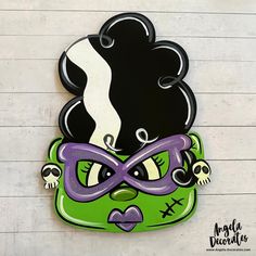 a green mask with black hair and purple glasses on it's face is hanging from the wall