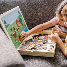 two children playing with a puzzle on the couch